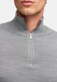 Grau melierter Zip-Knit-Pullover mit gerippter Struktur, ausgestattet mit einem halben Reißverschluss und einem hohen Kragen für zusätzliche Wärme und Komfort.