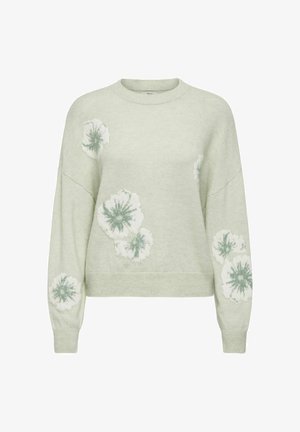 Hele roheline sviiter, millel on valge ja rohelise lillemuster, ümmargune kaelus ja langetatud õlavarred, valmistatud pehmest tekstuuriga materjalist.