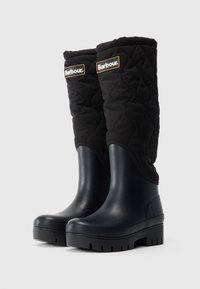 Bottes mi-mollet en tissu matelassé noir et caoutchouc avec de semelles épaisses crantées et des patchs du logo Barbour sur la tige supérieure.