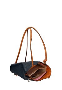 Sac en cuir d'autruche bleu marine avec des poignées beige. Il dispose d'un sommet ouvert, d'un intérieur spacieux et d'une doublure rose avec des poches pour l'organisation.