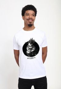 Bílé bavlněné tričko s černobílým grafickým motivem postavy s ostře nastylizovanými vlasy a kožešinovým límcem, označené "DEATH NOTE."