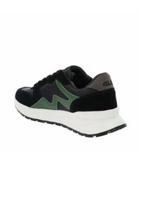 Zapatillas con una parte superior negra con acentos de ante verde y un talón de ante gris. Suela intermedia blanca gruesa y suela exterior de goma negra con patrón.