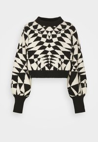 Pull cropped noir et blanc avec des motifs géométriques, encolure et poignets côtelés, et manches bouffantes. Texture en tricot douce.