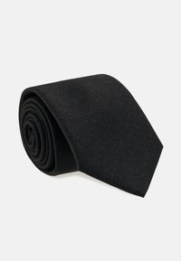 Svart tyg slips rullad, med en fin textur och subtila glittrande detaljer mot en enkel ljus bakgrund.