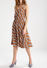 Hnědo-bíl dress s pruhy, se přiléhavým pasem, siluetou do A a tenkými ramínky, doplněné modrými lodičkami. Hladká textura.