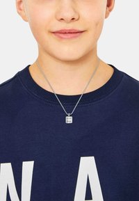 Collana d'argento con un pendente rettangolare, inciso con "Pause Break", indossata sopra una felpa blu scuro con lettere bianche.