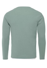 Camicetta verde chiaro a maniche lunghe con una texture a coste e un collo rotondo. Il retro presenta un design semplice senza loghi o decorazioni visibili.