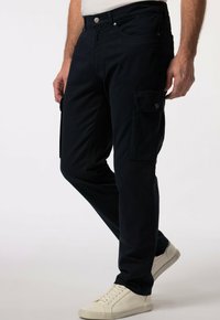 Námořnické cargo kalhoty s volným střihem, s bočními kapsami, zapínáním na knoflík a hladkou texturou látky. V kombinaci s bílými teniskami.