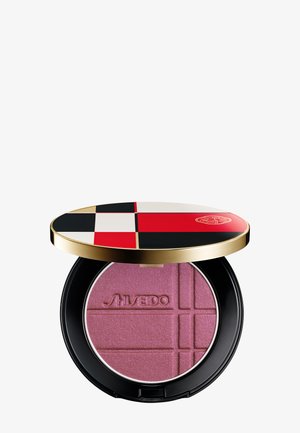 Compatto per trucco con cipria pressata rosa, con rilievo "Shiseido", e un coperchio rotondo con motivo geometrico rosso, nero, bianco e oro.