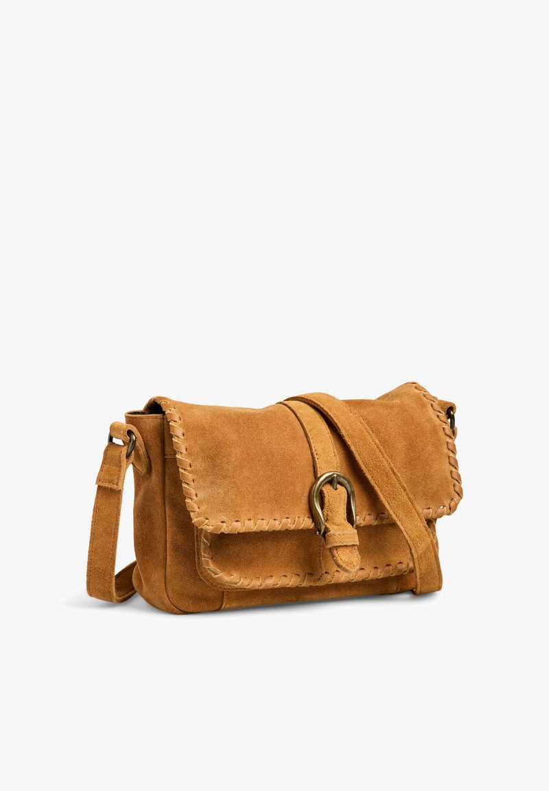 Sac bandoulière en daim marron avec des bords cousus, fermeture à boucle à l'avant et bandoulière ajustable sur fond blanc.