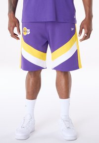 Lila kosárlabda nadrág sárga és fehér csíkos részletekkel, a "Los Angeles Lakers" logóval. Könnyű anyagból készült.