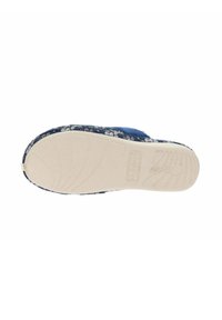 Zapato sin cordones azul con estampado floral, de parte superior oscura texturada y suela de goma clara con dibujo acanalado para mayor tracción.