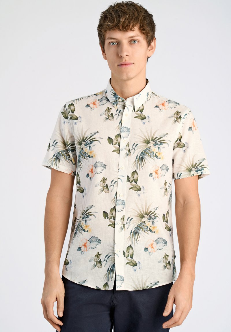 Camisa de manga corta abotonada en tela ligera con un patrón floral que presenta hojas verdes y flores de un naranja pálido sobre un fondo beige.