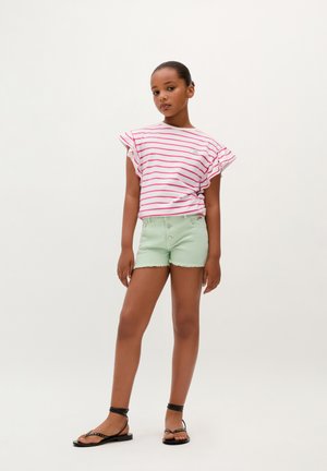 Hvid og lyserød stribet kortærmet top kombineret med mintgrønne denim shorts. Sorte sandaler med stropper og dekorative detaljer.