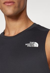 Μαύρο αμάνικο αθλητικό μπλουζάκι από λείο ύφασμα, με λευκό λογότυπο της "The North Face" στην αριστερή περιοχή του στήθους.