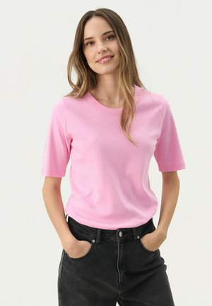 Lichtroze T-shirt met korte mouwen en een ronde hals, gemaakt van zachte stof, gecombineerd met hooggetailleerde zwarte jeans. Minimalistisch ontwerp.
