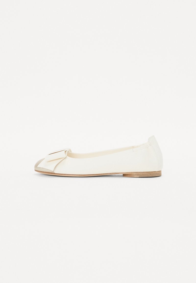 Chaussure plate de ballet couleur crème avec bout pointu et nœud décoratif à l'avant, dotée d'un petit talon en bois.