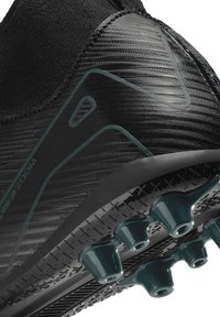 Baskets noires de sport avec une tige texturée, un design épuré et des pointes turquoise contrastantes sur la semelle pour une adhérence et une traction.