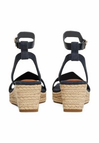 Zoccoli espadrille blu navy con tacco in juta intrecciata, cinturini alla caviglia regolabili e dettagli in pelle liscia. Design con schiena aperta e punta arrotondata.