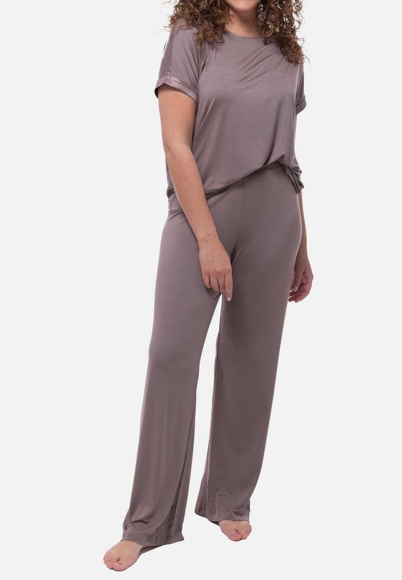 Ljus lavendellila loungewear-set som innehåller en kortärmad topp och löst sittande byxor. Mjukt material, avslappnad design och detaljer med sidoklipp på byxorna.