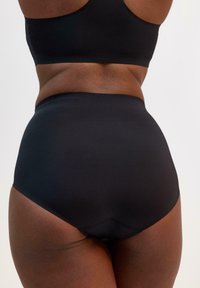 Mutande nere a vita alta con una texture liscia e un design senza cuciture, dotate di una fascia larga per comfort e copertura.