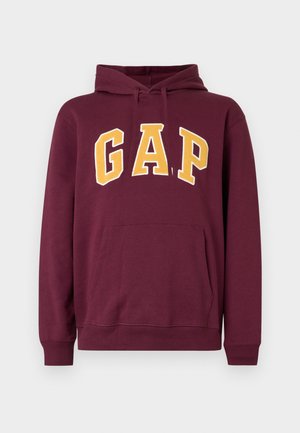 Sudadera con capucha color granate con letras en bloque amarillas "GAP" en el frente y un bolsillo tipo canguro debajo del logo.