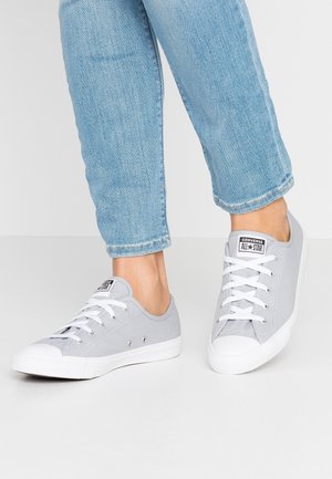 Baskets en toile grises au design bas, semelles en caoutchouc blanches et fermeture à lacets. Comprend un logo de marque sur la languette et des œillets en métal.
