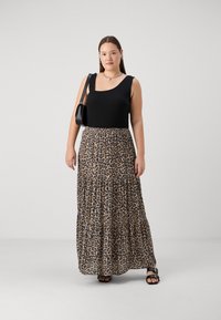 Černý bezrukávový top v kombinaci s tierovanou maxi sukní s leopardím vzorem, která má nařasený pas a texturovanou látku. Černé sandály na podpatku.