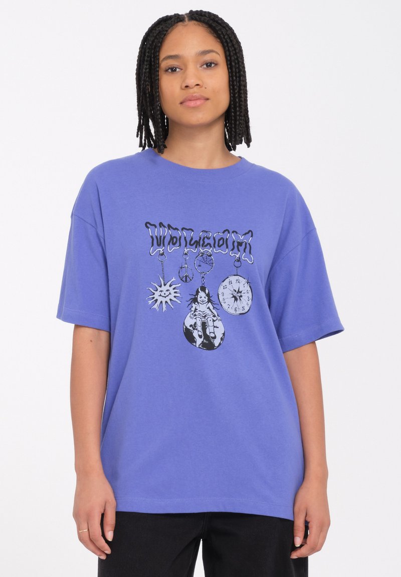 Camiseta de algodón morada de manga corta con estampado gráfico de un sol, un signo de paz, un reloj y una muñeca en la parte delantera. Diseño de corte relajado.