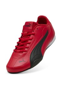 Scarpa sportiva rossa in pelle con accenti neri, finitura testurizzata, sistema di allacciatura e logo PUMA sulla linguetta e sul lato.