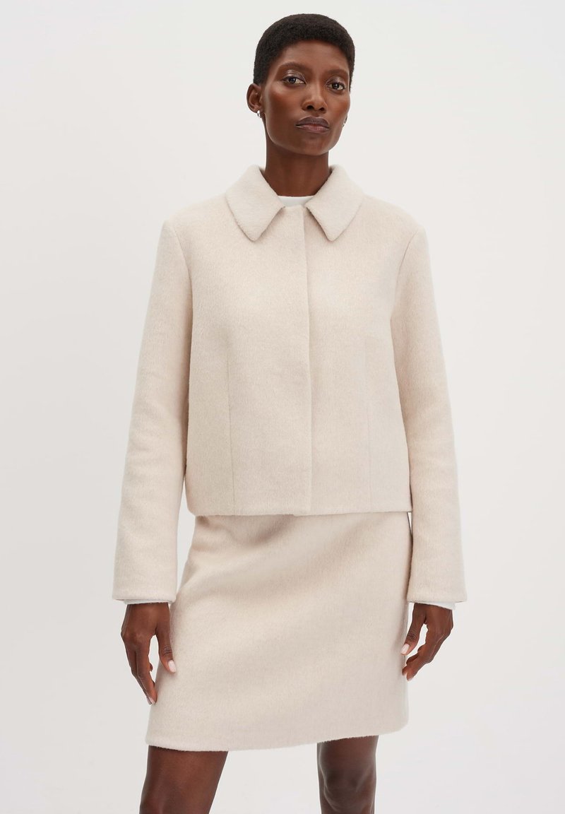 Licht beige wollen blend jas met een afgeronde kraag, lange mouwen en een getailleerd design, gecombineerd met een bijpassende mini rok. Glad textuur.