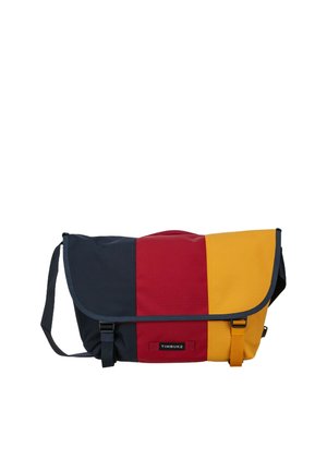 Crossbody messenger bag with navy blue, red, and yellow vertical panels, black adjustable strap, and front buckled flap closure.