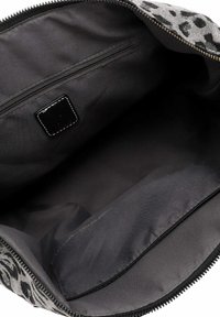Interno di un sacchetto di tessuto nero caratterizzato da una texture liscia, una tasca con zip e un accento in pelle nera. Design circolare a stampa leopardata sull'esterno.