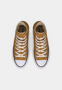 Καφέ πάνινα ψηλά αθλητικά παπούτσια με λευκά κορδόνια, μαύρα λάστιχα στα δάχτυλα και λευκή σόλα, με απλό, κλασικό σχέδιο.