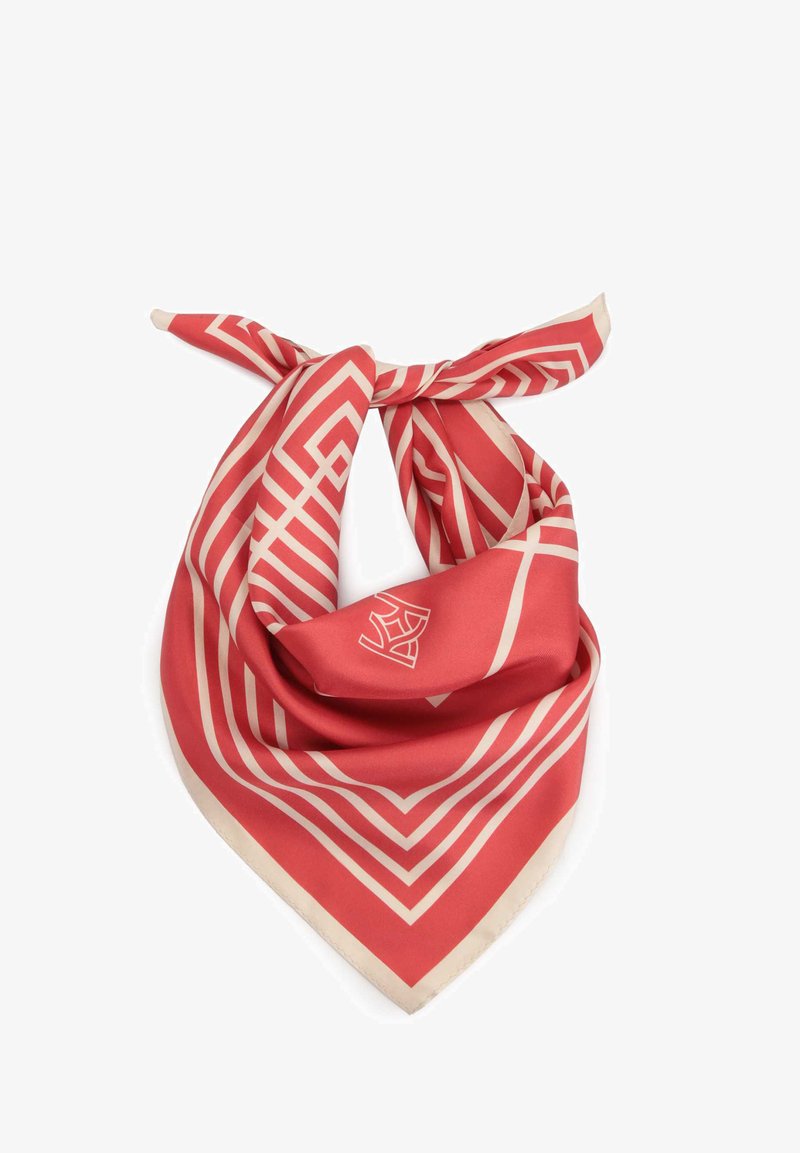 Pañuelo de seda rojo con franjas geométricas beige y un logo, atado en un nudo. Los bordes están terminados con un dobladillo beige claro.