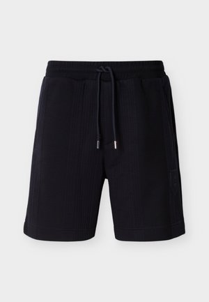 Shorts texturés bleu marine avec taille à cordon, poches latérales et petit écusson logo sur le côté gauche. Longueur mi-cuisse.