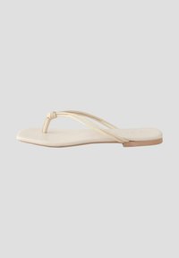 Platt tongsandal med två tunna beige remmar, rund tåpost och en slät sula, som visar upp en minimalistisk design och neutral färg.