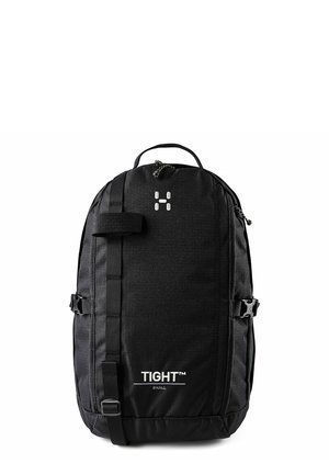 Zwarte compacte rugzak met voorste band, zijgespen, bovenste handvat en witte tekst "TIGHT SMALL" aan de voorkant.