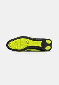 Neoonkollane ja must spordijalatsite talla tekstureeritud ringikujuliste mustritega, mille keskel on tekst "NIKE SWO".