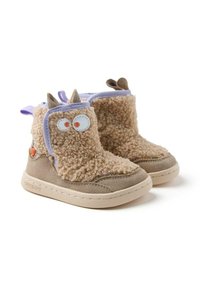 Botas de forro polar marrón con acentos morados, ojos blancos redondos y orejas pequeñas. Textura suave, suela de goma y detalles cosidos a lo largo de los bordes.