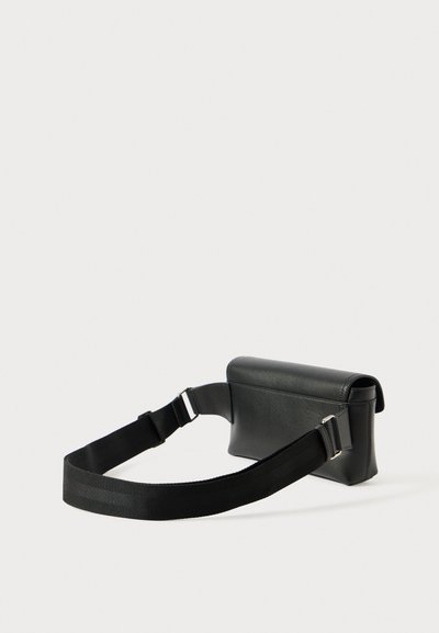 Must päikesepruun nahkrist crossbody kott ruudukujulise disainiga, lamedate sulgemisega ja reguleeritava musta rihmaga. Omab hõbedatooni detailide aktsente.