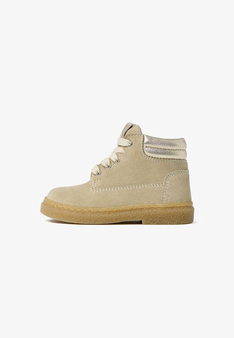 Beiger Wildleder-Stiefelette mit goldenem Metallic-Akzent, traditionellen Schnürsenkeln und einer strukturierten Gummisohle für besseren Halt. Mit gesteppten Details.