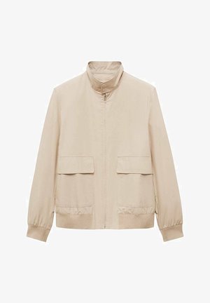 Giacca beige chiaro con colletto alto, zip frontale e due ampie tasche frontali. Presenta polsini elasticizzati e una finitura liscia opaca.