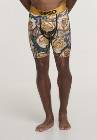 Boxer da uomo con fascia in vita color oro. Il motivo presenta rose gialle e foglie verdi su uno sfondo scuro. Tessuto elasticizzato, taglio aderente.