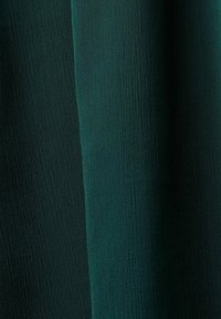 Tissu texturé vert foncé avec des plis verticaux et un motif subtil en forme de grille sur la surface.