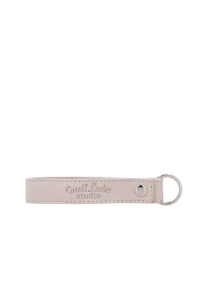 Beiger Leder-Schlüsselanhänger mit einem silbernen Metallring und "Gusti Leder studio" auf dem Lederband graviert.