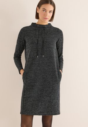 Zwarte trui jurk van textuurstof, met lange mouwen, een hoge kraag, trekkoorddetail en zijzakken. Eenvoudig ontwerp met een relaxte pasvorm.