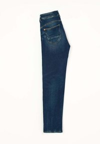 Jeans en denim bleu foncé avec une coupe slim, dotés d'une poche arrière et de détails de couture visibles, texture lisse et taille mi-haute.