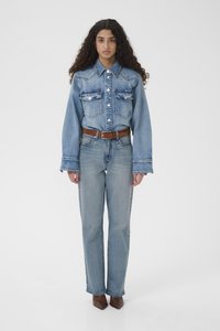 Svetlomodrá rifľová košeľa s dvoma náprsnými vreckami, zapínaním na gombíky a širokými rukávmi, skombinovaná so svetlomodrými džínsami a hnedým koženým opaskom. Hnedé špicaté topánky.