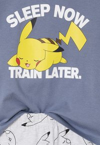 Sleeping yellow Pikachu with closed eyes above the text “SLEEP NOW TRAIN LATER” on blue fabric with Pikachu face patterns below.
